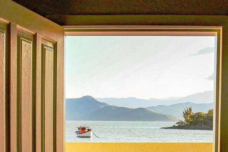 Beira-mar, piscina e vista montanha com pôr do sol