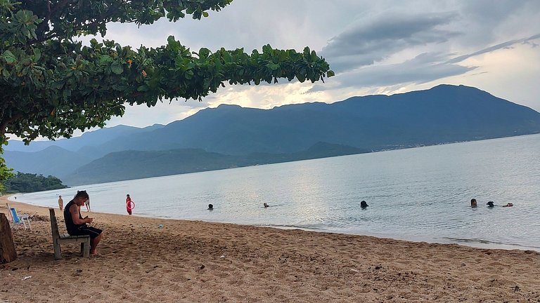 Beira-mar, piscina e vista montanha com pôr do sol