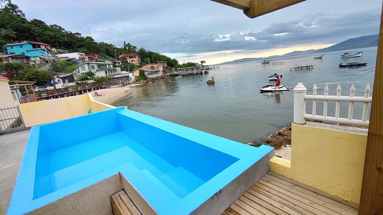 Beira-mar, piscina e vista montanha com pôr do sol