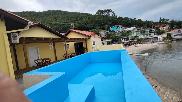 Beira-mar, piscina e vista montanha com pôr do sol