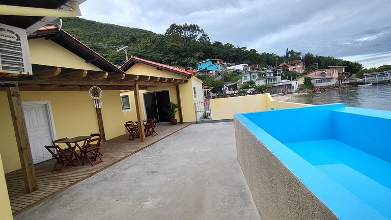 Beira-mar, piscina e vista montanha com pôr do sol