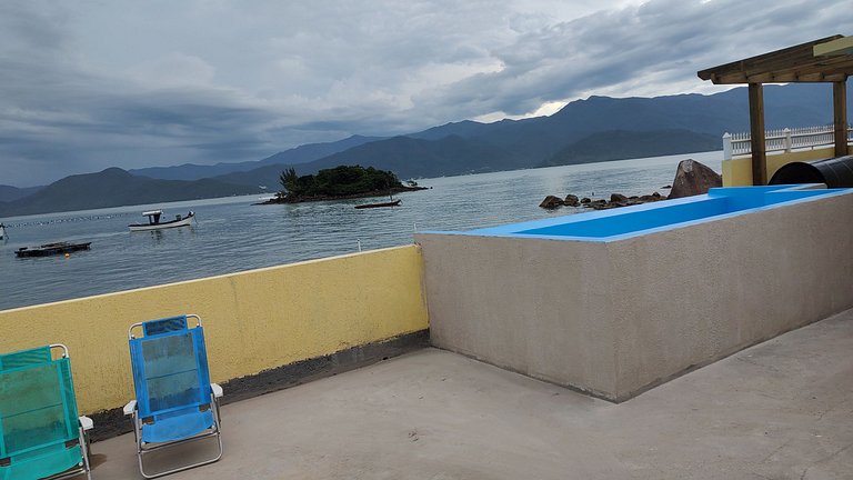 Beira-mar, piscina e vista montanha com pôr do sol