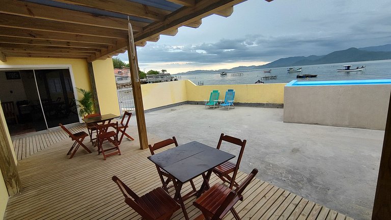 Beira-mar, piscina e vista montanha com pôr do sol