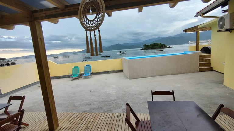 Beira-mar, piscina e vista montanha com pôr do sol