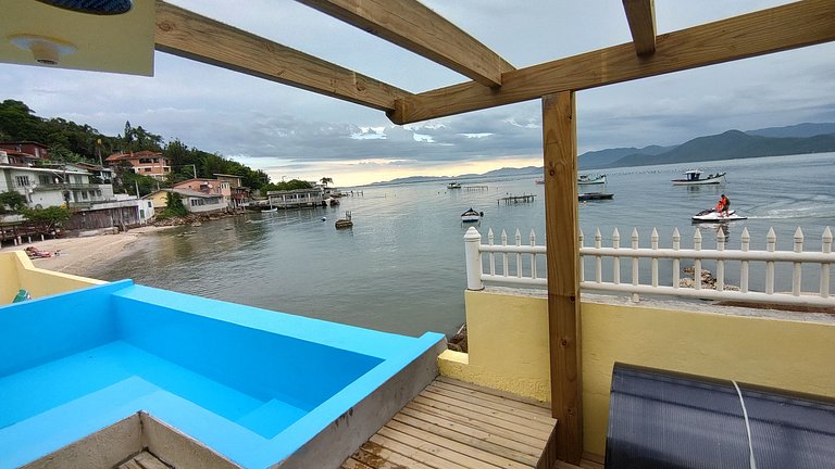 Beira-mar, piscina e vista montanha com pôr do sol