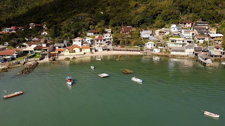 Beira-mar, piscina e vista montanha com pôr do sol