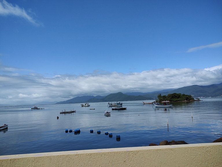 Beira-mar, piscina e vista montanha com pôr do sol