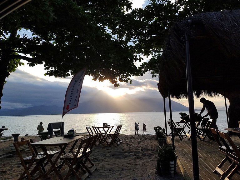 Beira-mar, piscina e vista montanha com pôr do sol